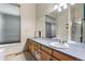 Bathroom featuring a wood vanity with sink and mirror and a large window with a privacy shade at 4290 S Deframe St, Morrison, CO 80465