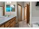 Bright bathroom featuring a wood vanity with double sinks, a large mirror, and a tile shower at 4290 S Deframe St, Morrison, CO 80465