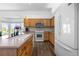 Bright kitchen featuring wood cabinets, white appliances, and a large center island with bar seating at 4290 S Deframe St, Morrison, CO 80465