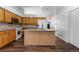 Open kitchen featuring wood cabinets, white appliances, an island with bar seating, and modern pendant lighting at 4290 S Deframe St, Morrison, CO 80465