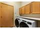 Laundry room with a washer, dryer, cabinets, and a door at 4290 S Deframe St, Morrison, CO 80465