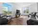 Bright living room with large windows, hardwood floors, and comfortable leather seating at 4290 S Deframe St, Morrison, CO 80465