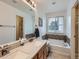 Well-lit bathroom with double sinks, a soaking tub, and modern fixtures, offering a spa-like experience at 426 N 48Th Ave, Brighton, CO 80601