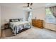 Cozy bedroom with a large bed, carpeted floors, and ample natural light from two windows at 426 N 48Th Ave, Brighton, CO 80601