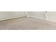Carpeted basement area featuring neutral-colored walls, baseboard heater and a white door at 2172 S Harlan St, Denver, CO 80227