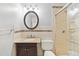 Cozy bathroom featuring granite countertop vanity, round mirror, and walk-in shower with marble-patterned walls at 2172 S Harlan St, Denver, CO 80227
