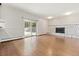 A spacious living room with wood floors, a stone fireplace, and a sliding glass door at 2172 S Harlan St, Denver, CO 80227
