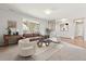 Bright living room featuring a brown couch, white chairs, neutral rug and brick accented windows at 2172 S Harlan St, Denver, CO 80227