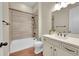 Clean bathroom featuring modern vanity, shower-tub with unique tiling, and wood look floors at 5190 Ditmars Trl, Castle Rock, CO 80104