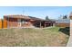 A wide open backyard featuring a covered patio, lots of green grass, and an ideal space for gatherings and play at 96 S Depew Dr, Lakewood, CO 80226