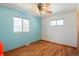 Empty bedroom featuring a window, light fixture, hardwood floors, and paint in a two-tone design at 96 S Depew Dr, Lakewood, CO 80226
