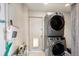 Laundry room with a stacked washer and dryer set, cleaning supplies, and a door to the outside at 96 S Depew Dr, Lakewood, CO 80226