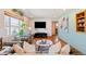 Bright living room with hardwood floors, large windows, a modern TV, and comfortable, stylish furnishings at 96 S Depew Dr, Lakewood, CO 80226