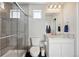 Modern bathroom with gray tile shower, glass door, decorative tile accents, and granite vanity at 18066 E 104Th Way, Commerce City, CO 80022