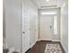 Bright entryway featuring a white door, overhead window, hardwood floors, and stylish black and white rug at 18066 E 104Th Way, Commerce City, CO 80022