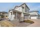 A two-story home featuring stone accents, a covered porch, a two-car garage, and a well-maintained landscape at 18066 E 104Th Way, Commerce City, CO 80022