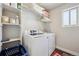 Well-organized laundry room with modern washer and dryer, ample shelving for supplies, and a window at 18066 E 104Th Way, Commerce City, CO 80022