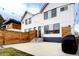 The home's backyard features a cement patio area with a wooden fence, black grill, and string lighting at 2471 S High St, Denver, CO 80210