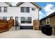 The home's backyard features a cement patio area with a wooden fence, black grill, and a staircase at 2471 S High St, Denver, CO 80210