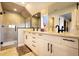 Modern bathroom with double vanity, black hardware, large mirrors, and a glass-enclosed shower, creating a luxurious spa-like experience at 2471 S High St, Denver, CO 80210