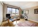 Cozy bedroom with hardwood floors, a comfortable chair, and a large window with neighborhood views at 2471 S High St, Denver, CO 80210