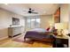 Bright bedroom featuring hardwood floors, a large window, ceiling fan, and a modern dresser, creating a cozy and stylish retreat at 2471 S High St, Denver, CO 80210