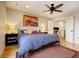 A bedroom featuring hardwood floors, a bed with a blue duvet, and an adjacent loft space with a desk at 2471 S High St, Denver, CO 80210