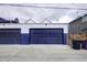 Wide shot of a two-car garage with two doors, painted white and blue with a concrete floor at 2471 S High St, Denver, CO 80210