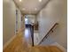 Bright hallway with hardwood floors, modern railing, and an opening to a bedroom, providing a seamless and stylish transition at 2471 S High St, Denver, CO 80210