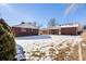 Spacious backyard with snow-covered lawn and brick home at 2994 S Winona Ct, Denver, CO 80236