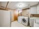 Basement laundry room with washer, dryer, and countertop at 2994 S Winona Ct, Denver, CO 80236