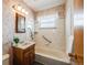 Bathroom with tub, shower, vanity, and wood cabinet at 2994 S Winona Ct, Denver, CO 80236