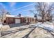 Front view of a brick ranch home with driveway and snowy yard at 2994 S Winona Ct, Denver, CO 80236