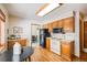 Kitchen features wood cabinets, white appliances, and views to dining area at 2994 S Winona Ct, Denver, CO 80236