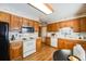 Kitchen with wood cabinets, white appliances, and a small breakfast nook at 2994 S Winona Ct, Denver, CO 80236