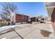 Brick home with a covered patio and spacious concrete area at 2994 S Winona Ct, Denver, CO 80236