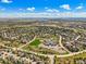 Expansive aerial shot capturing a residential community, nearby park, and scenic lake views at 907 Greenridge Ln, Castle Pines, CO 80108
