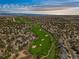 Breathtaking aerial view of a golf course community nestled in a picturesque landscape with mountain views at 907 Greenridge Ln, Castle Pines, CO 80108