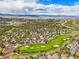 Stunning aerial perspective of a golf course winding through a residential area with mountain backdrop at 907 Greenridge Ln, Castle Pines, CO 80108
