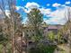 Home's exterior from the back shows multi-level deck and backyard surrounded by lush trees at 907 Greenridge Ln, Castle Pines, CO 80108