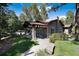 Charming clubhouse exterior featuring a covered entrance, stone chimney, and well-maintained landscaping at 907 Greenridge Ln, Castle Pines, CO 80108