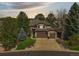 Charming two-story home featuring a three-car garage, stone accents, and mature trees at 907 Greenridge Ln, Castle Pines, CO 80108