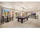 Spacious game room with pool table, bar seating, and an adjacent dining area at 907 Greenridge Ln, Castle Pines, CO 80108
