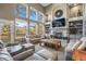 Bright living room with soaring ceilings, fireplace, built-in shelving, and large windows at 907 Greenridge Ln, Castle Pines, CO 80108