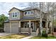 Charming two-story home with a covered front porch, two-car garage, and mature trees at 16434 Homestead Ct, Parker, CO 80134
