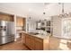 Charming kitchen with wood cabinets, granite counters, stainless appliances, and an island with seating at 16434 Homestead Ct, Parker, CO 80134