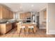 Charming kitchen with wood cabinets, granite counters, and an island with seating at 16434 Homestead Ct, Parker, CO 80134