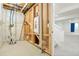 A basement space with visible wall structure, pipes, and electrical components, next to a finished carpeted area at 26322 E 2Nd Ave, Aurora, CO 80018