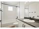 Bathroom with a white tiled shower over tub and a vanity with black fixtures and hardware at 26322 E 2Nd Ave, Aurora, CO 80018