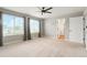 Spacious bedroom features bright windows, carpet, a fan, and an ensuite bathroom at 26322 E 2Nd Ave, Aurora, CO 80018